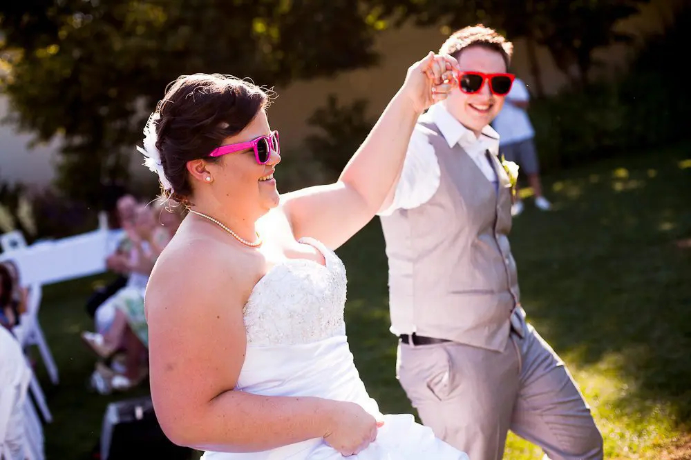 bride and groom just after ceremony bride and groom wearing fun sun glasses after being married