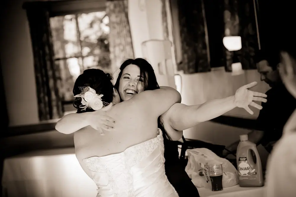 bride and maid of honor hugging after toast cute photo of bride and bride's maid