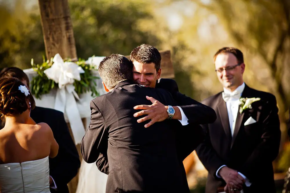groom hugging father of the bride the groom accepting the bride from her father