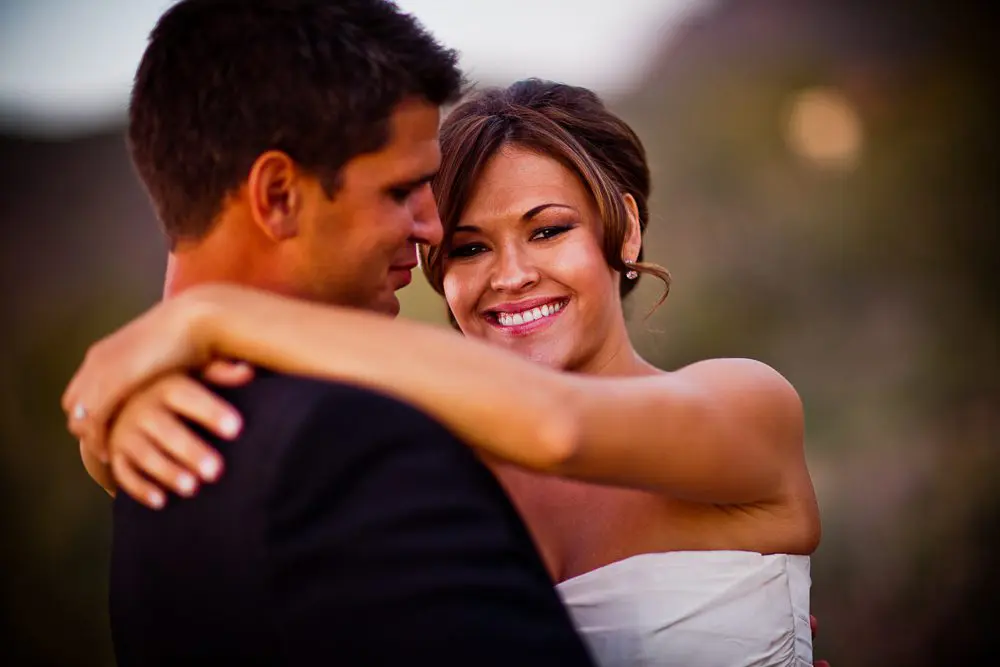 bride hugging groom bride smiling at the camera