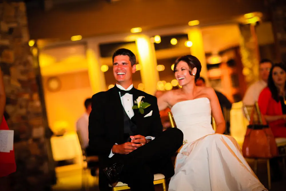 bride and groom smiling at reception bride and groom laughing during best man speech