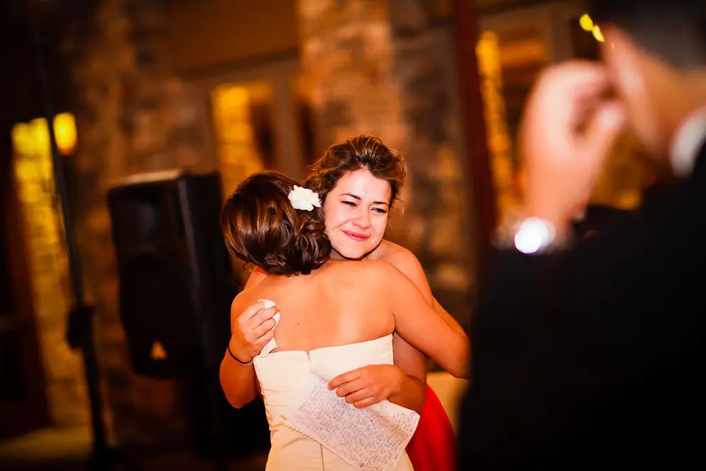 sister of the bride after her speech bride and bride's maid hugging after her speech