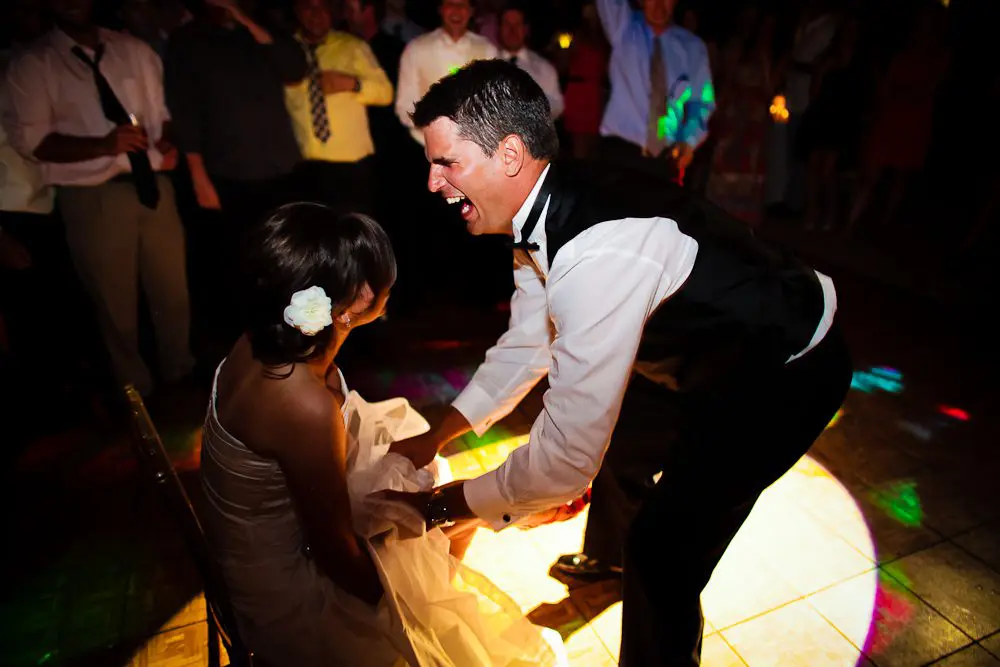 the garter toss groom laughing before going for the garter belt