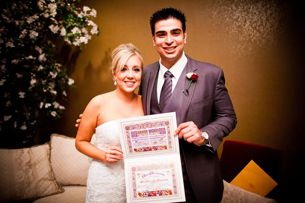 the bride and groom smiliing with the marriage certificate