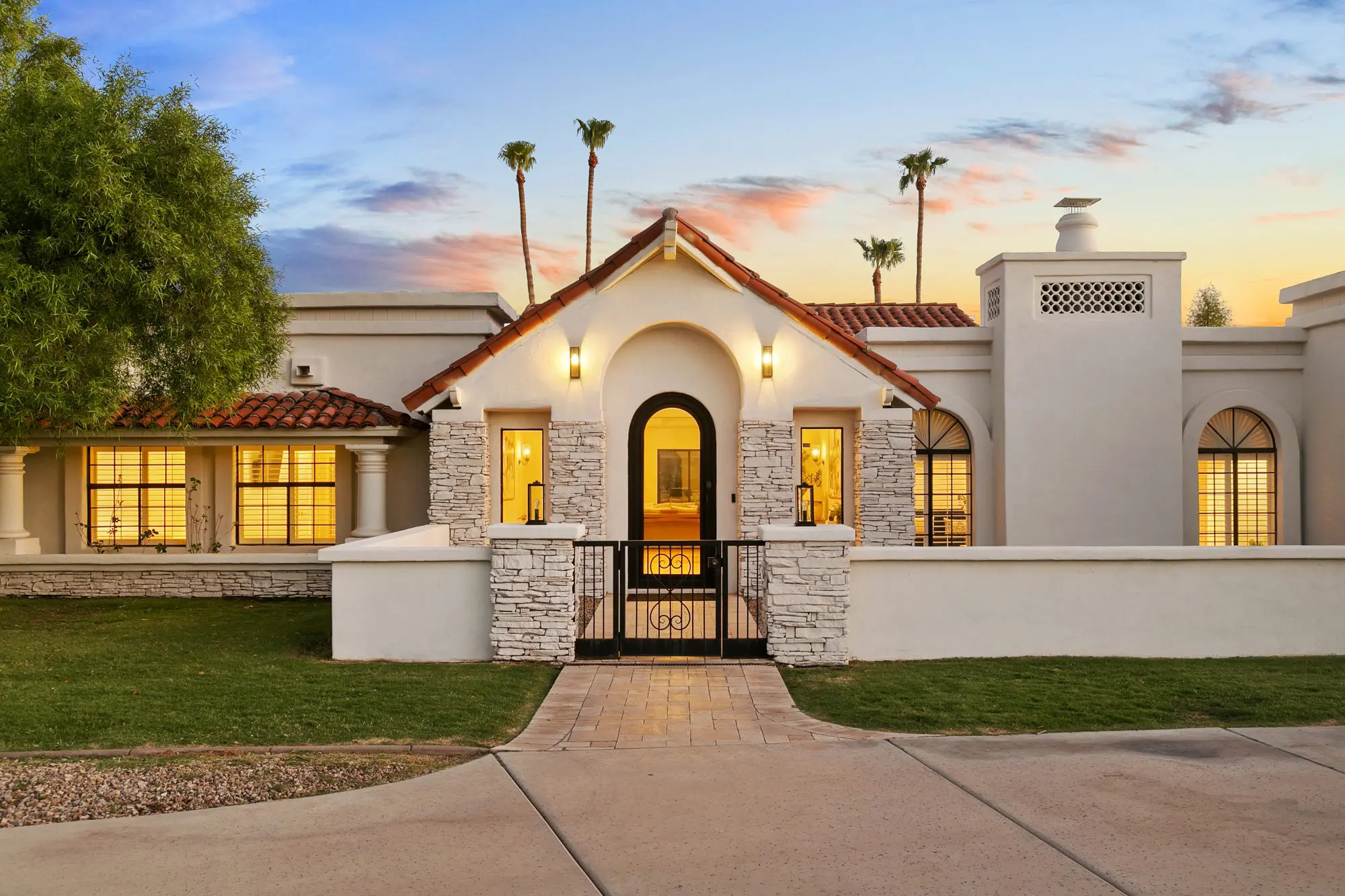 McDowell Ranchos Scottsdale luxury home twilight exterior, Spanish tile and stone entry