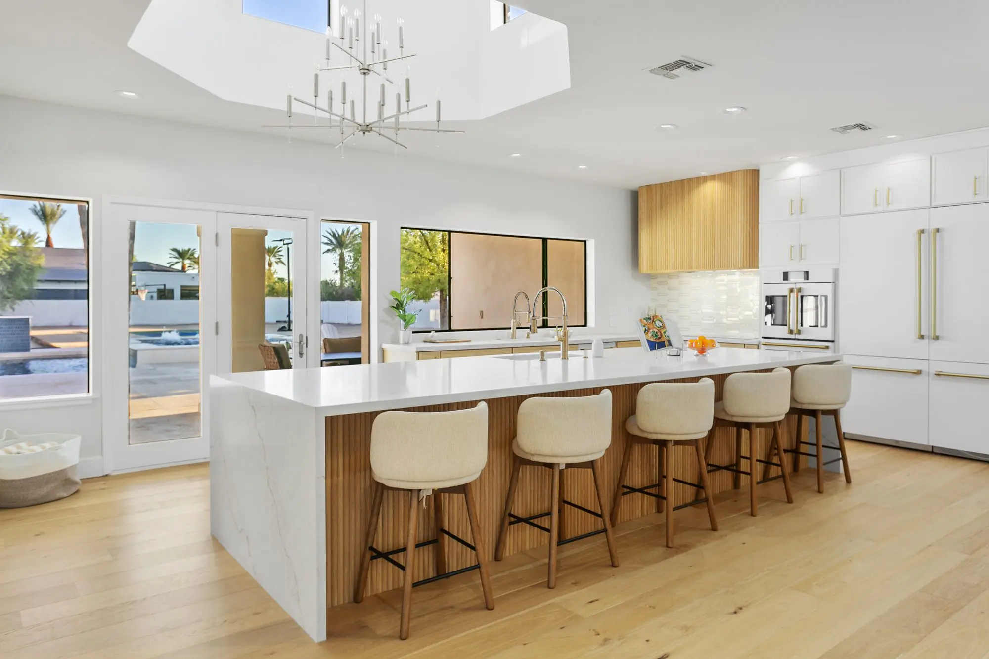 Kitchen with waterfall marble island and wood cabinetry