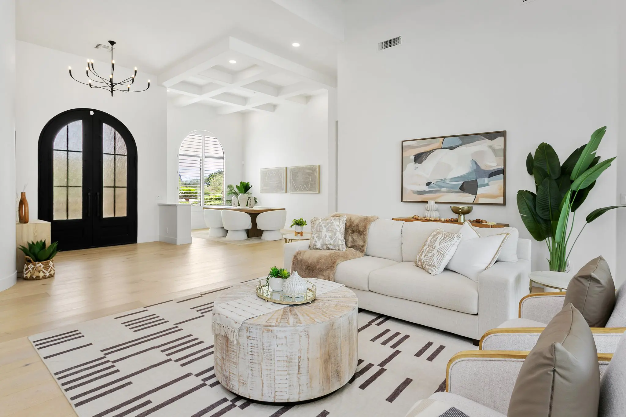 Living room with arched black front doors and chandelier, Scottsdale interior photography