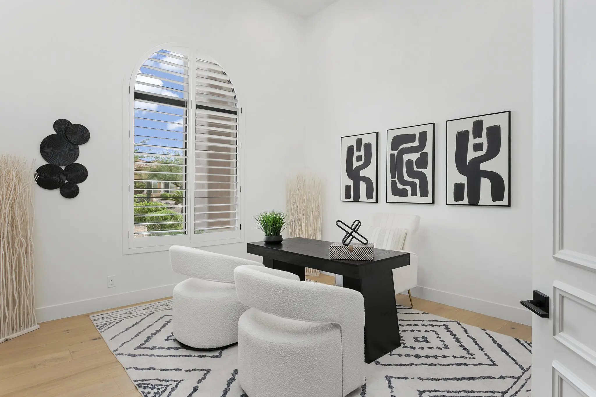 Home office with arched shuttered window and black desk