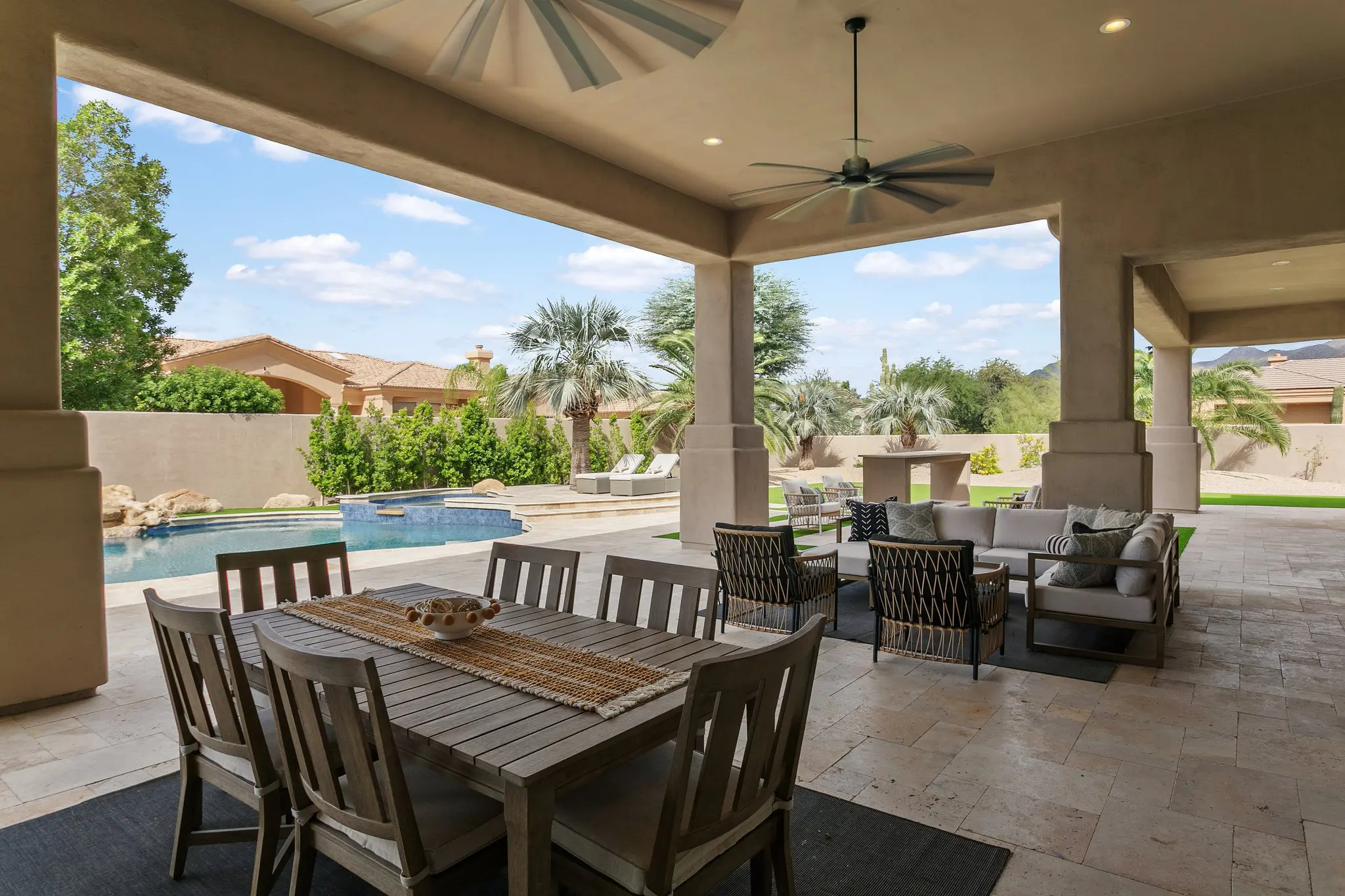 Covered patio with outdoor dining, ceiling fan and pool view