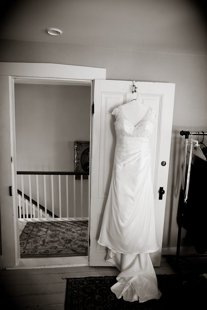 artistic shot of wedding dress hanging on door
