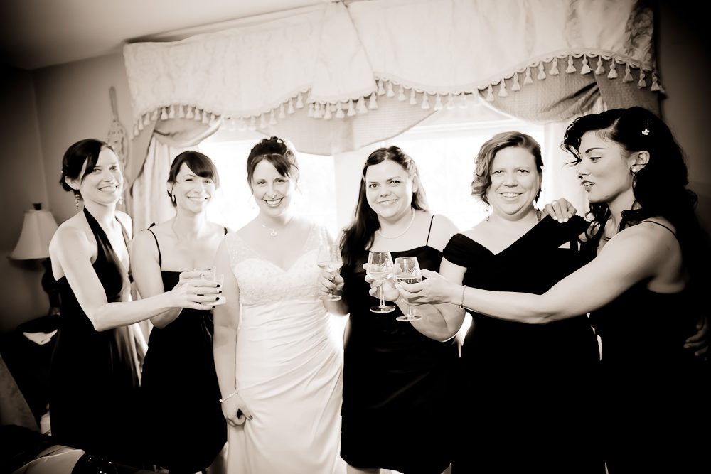 bride with bridesmaids while getting ready