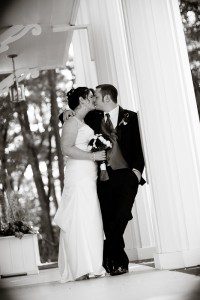 couple kissing during formals leaning on a pillar