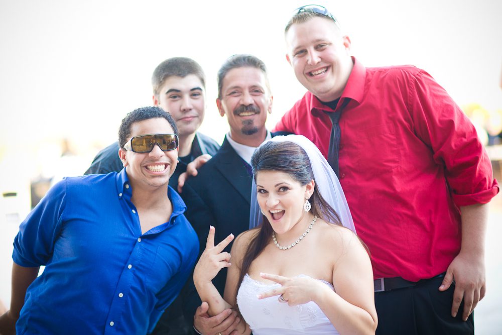 fun shot of bride with father and friends at reception