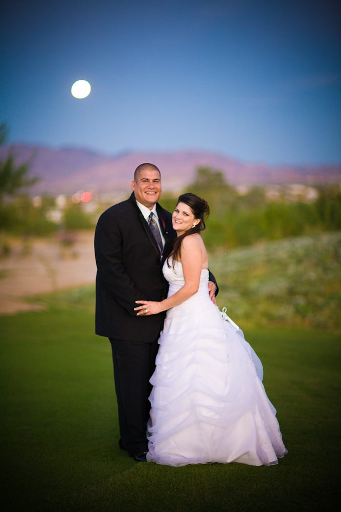 Bride and Groom with moon in background at magic hour on golf course