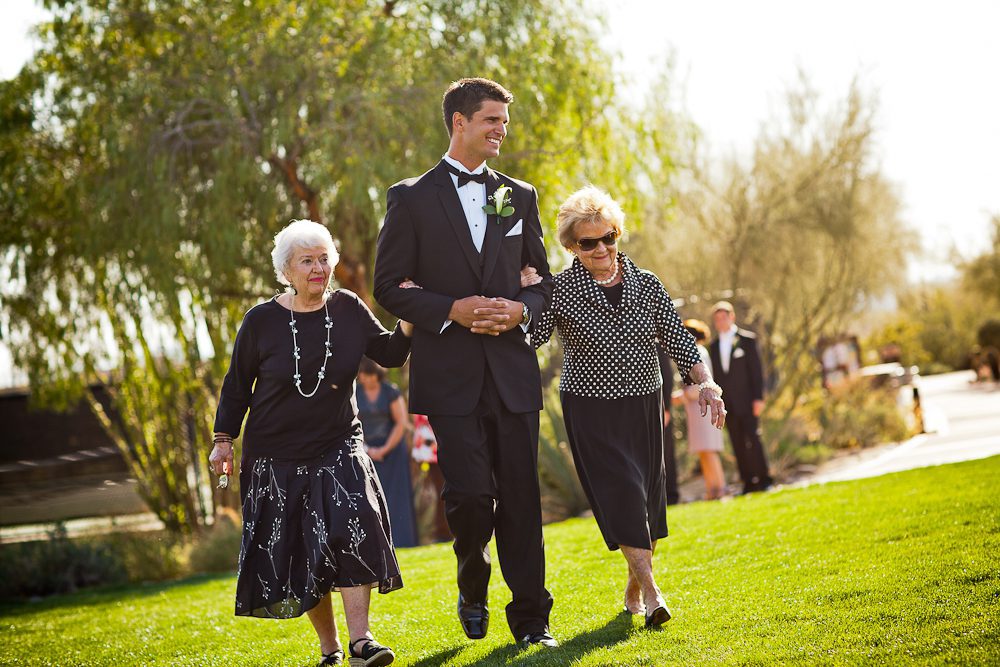 The groom walks his grandmas down the aisle