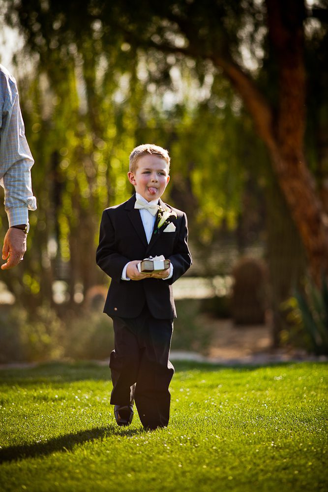 The ring bearer making a funny face before walking down the aisle