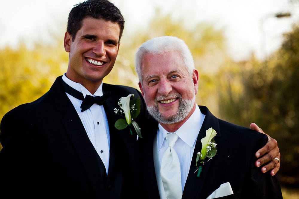 the groom and father in law smiling for a formal photograph