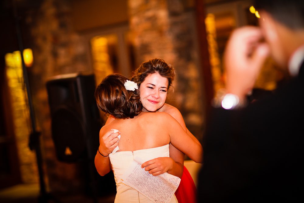 bride and bride's maid hugging after her speech