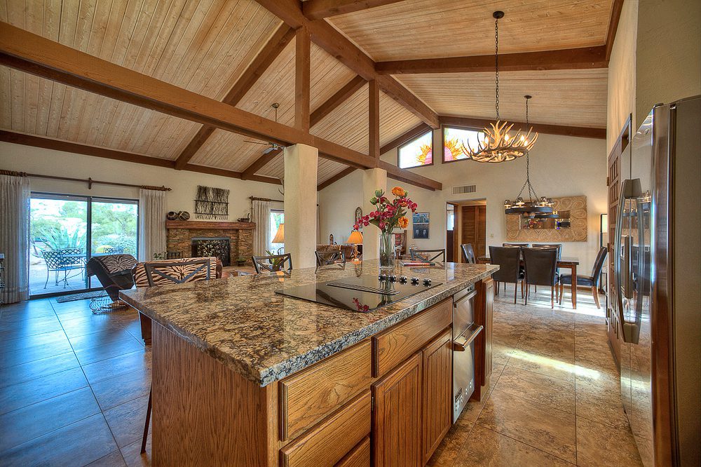kitchen counters with view of dining area and fireplace