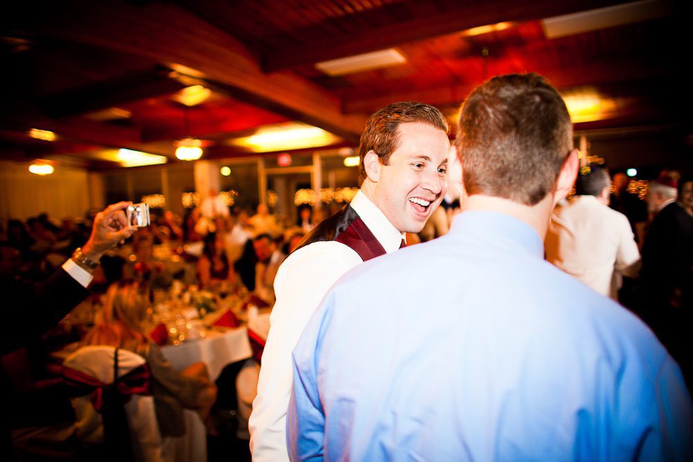 a groomsmen laughing during the reception